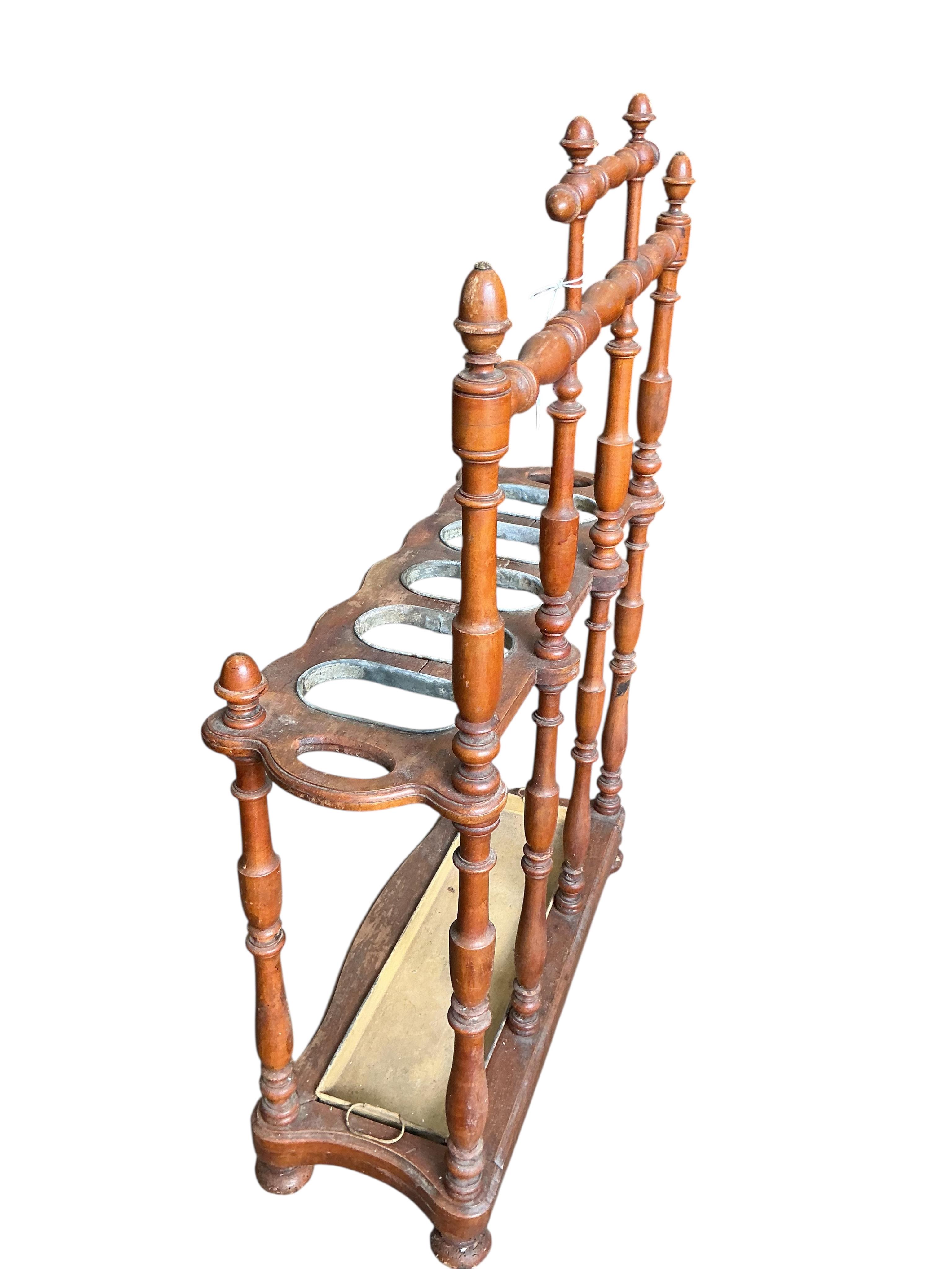 A late 19th / early 20th century French turned fruitwood five division stick stand, with tin drip tray, width 72cm, depth 28cm, height 112cm